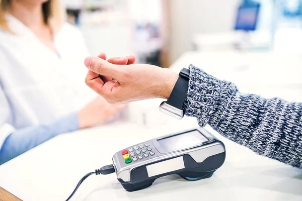 Un cliente que realiza un pago inalámbrico o sin contacto usando smartwatch . — Foto de Stock