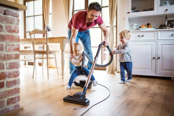 Vader en twee peuters doen van huishoudelijk werk. — Stockfoto