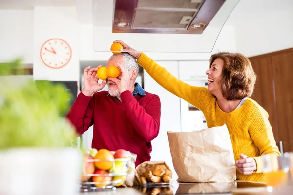 Äldre par uppackning mat i köket, ha roligt. — Stockfoto
