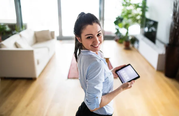 Een vrouw met een tablet met smart home scherm thuis. — Stockfoto