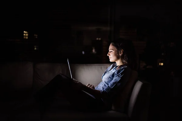Женщина, работающая над ноутбуком ночью дома . — стоковое фото