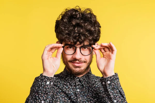 Studio portret van een jonge man op een gele achtergrond. — Stockfoto