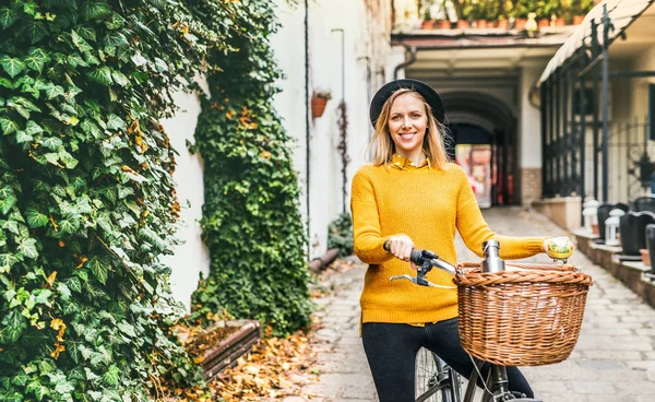 Junge Frau mit Fahrrad in sonniger Frühlingsstadt. — Stockfoto