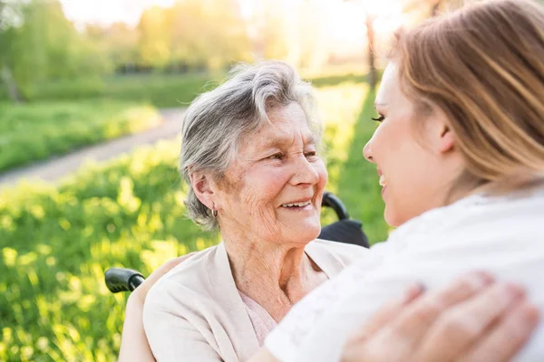 Äldre mormor i rullstol med barnbarn i vår natur. — Stockfoto