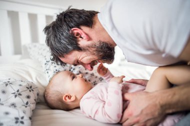 Babam yatmadan evde yatakta bir yürümeye başlayan çocuk kızla.