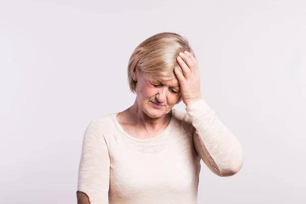 Studioporträt einer Seniorin im Schmerz. — Stockfoto