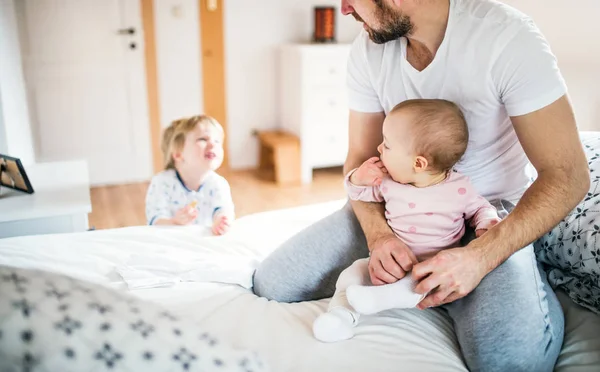 Otec s dětmi batole v ložnici doma před spaním. — Stock fotografie