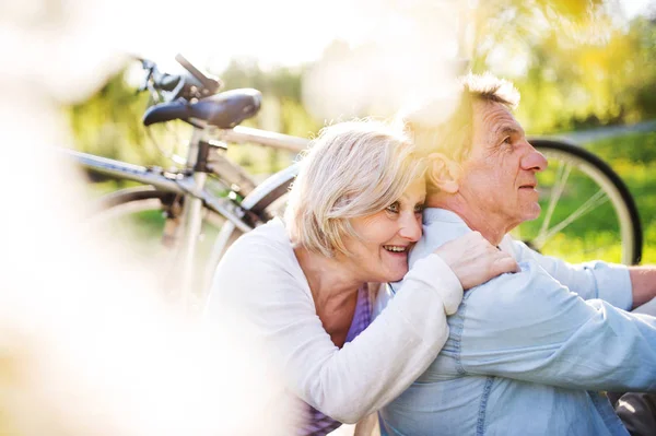 Beautiful senior couple with bicycles outside in spring nature. — Stock Photo, Image