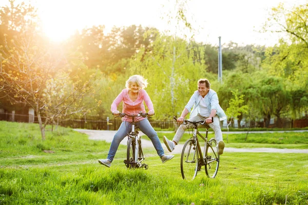 Beau couple aîné avec vélos à l'extérieur dans la nature printanière . — Photo