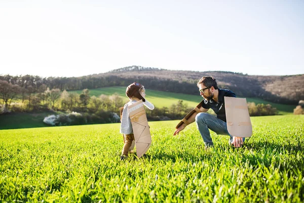 Joyeux tout-petit garçon jouer à l'extérieur avec père au printemps nature . — Photo