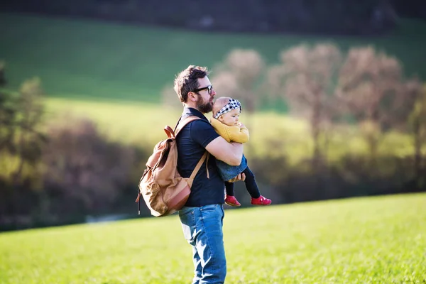 Um pai com sua filha criança lá fora na natureza primavera . — Fotografia de Stock