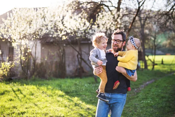 Seorang ayah dengan anak-anak balita luar di alam musim semi . — Stok Foto