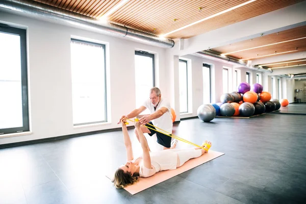 Senior mannelijke fysiotherapeut werken met een vrouwelijke patiënt. — Stockfoto