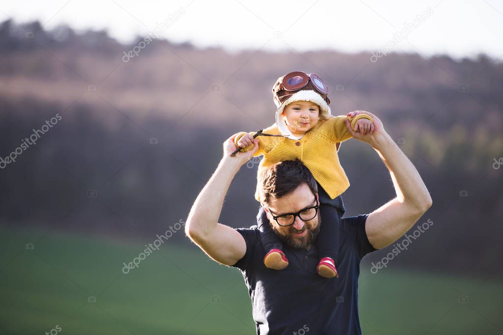 A father with his toddler daughter outside in spring nature.