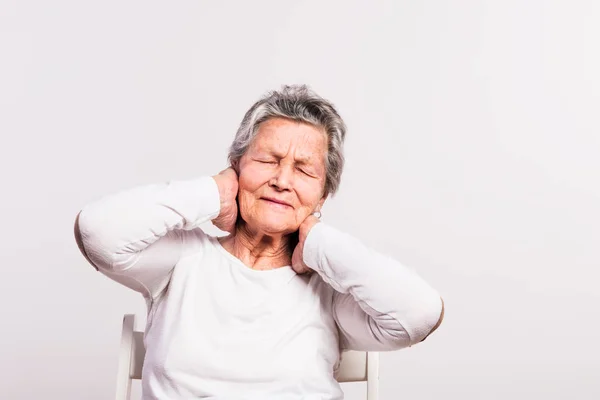 Studio porträtt av en äldre kvinna i smärta på en vit bakgrund. — Stockfoto