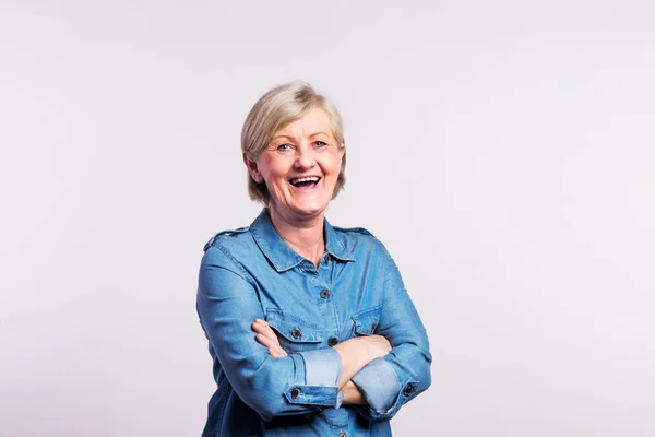 Portrait of a happy senior woman in studio, on a white background. — Stock Photo, Image