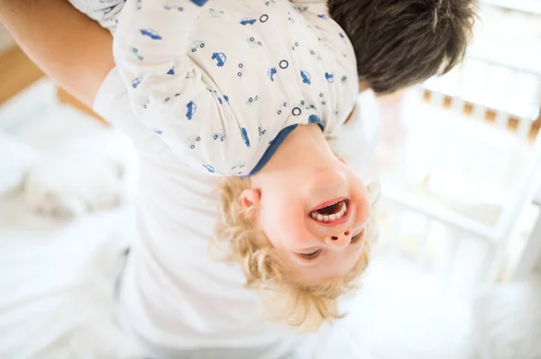 Pai segurando um menino feliz de cabeça para baixo . — Fotografia de Stock