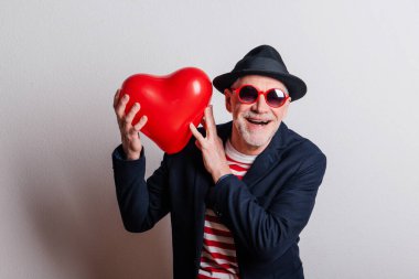 Stüdyoda aşık bir adamın portresi. Elinde kırmızı kalp balonu var..