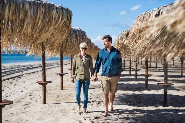 Casal jovem andando ao ar livre na praia, de mãos dadas. Espaço de cópia . — Fotografia de Stock