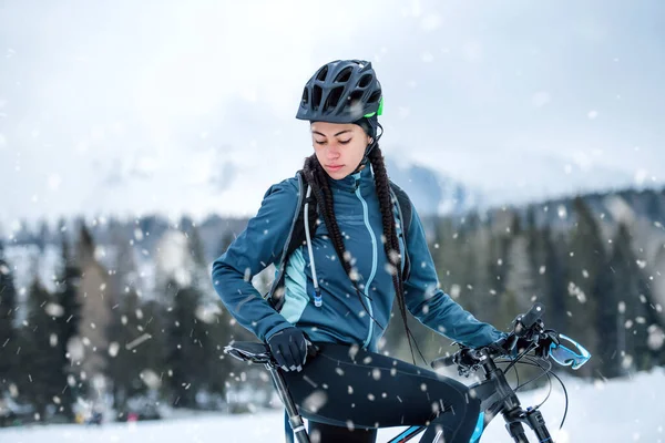 冬の自然の中で屋外に立つ女性マウンテンバイク. — ストック写真