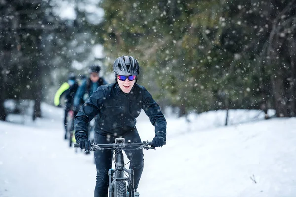 Skupina horských bikerů jezditelů v zimě na cestách ven. — Stock fotografie