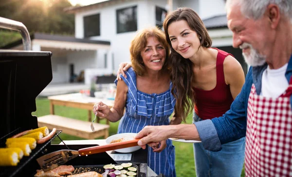 Portrét multigenerační rodiny venku na zahradním grilu, grilování. — Stock fotografie