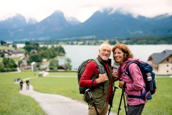 Senior důchodce pár s nordic vycházkové hole turistika v přírodě. — Stock fotografie