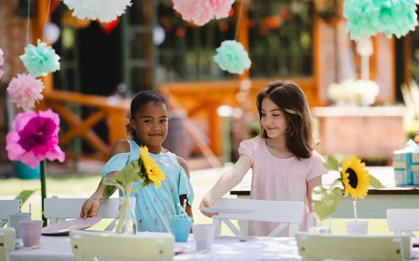 Små flickor dukning bord för sommar trädgårdsfest, födelsedag firande koncept. — Stockfoto