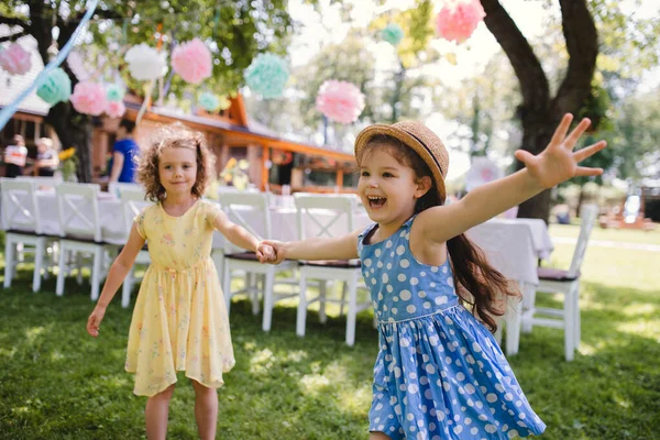 Small girls running outdoors in garden in summer, birthday celebration concept. — Stock Photo, Image
