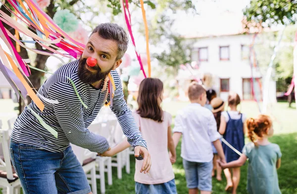 Uomo con bambini alla festa di compleanno giocando all'aperto in giardino in estate . — Foto Stock