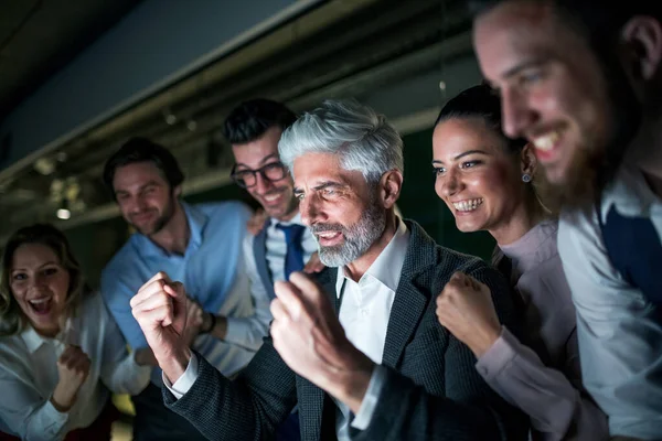 Un grupo de empresarios con ordenador en una oficina, expresando emoción . — Foto de Stock