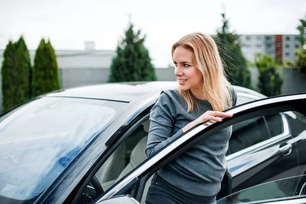 Jovem mulher saindo do carro na cidade . — Fotografia de Stock