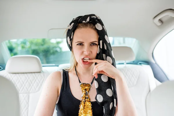 Молодая женщина сидит на заднем сиденье в машине, собирается на вечеринку и весело . — стоковое фото