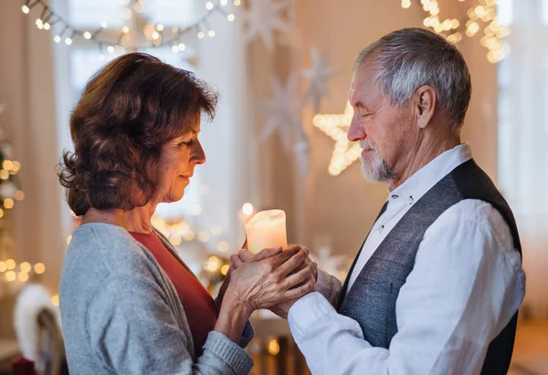 Vue latérale de heureux couple de personnes âgées à l'intérieur célébrant Noël . — Photo