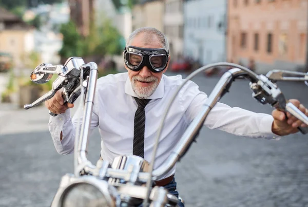 城中戴护目镜、骑摩托车的资深商人的前景. — 图库照片