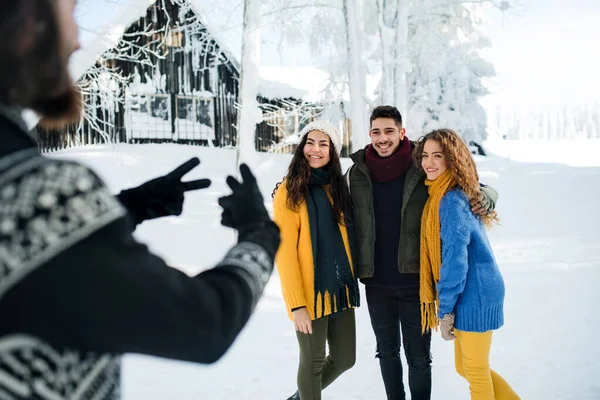 En grupp unga vänner på en promenad utomhus i snö på vintern. — Stockfoto