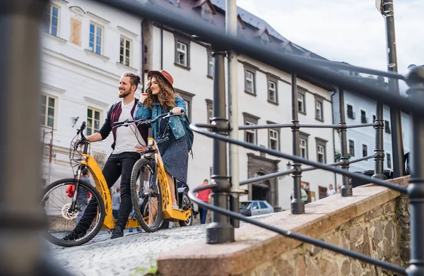 Küçük bir kasabada elektrikli scooter ile genç turist çift gezginler. — Stok fotoğraf