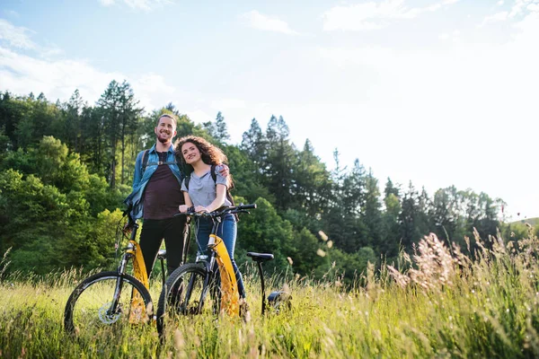 Jovens turistas casal viajantes com scooters elétricos na natureza . — Fotografia de Stock