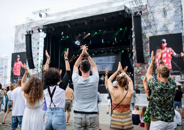 Achteraanzicht van groep jonge vrienden die dansen op zomerfestival. — Stockfoto