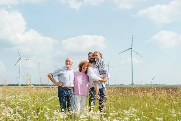 多代家庭站在风电场的田地里. — 图库照片