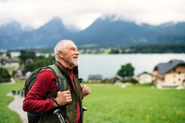 Uomo anziano con zaino escursioni nella natura, riposo. Copia spazio . — Foto Stock