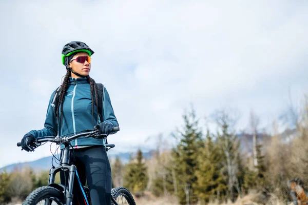 Žena horský cyklista stojící venku v zimě příroda. — Stock fotografie