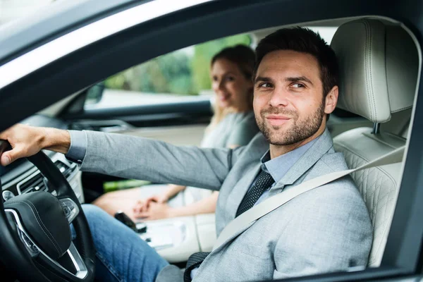 Una joven pareja sentada en coche, conduciendo . — Foto de Stock