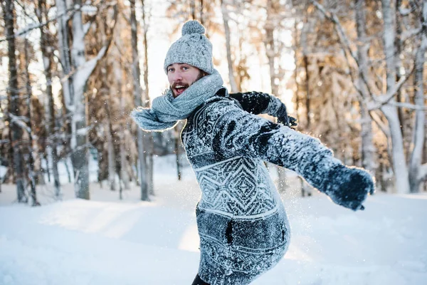Mladý muž, který se v zimě baví ve sněhu venku, skáče. — Stock fotografie
