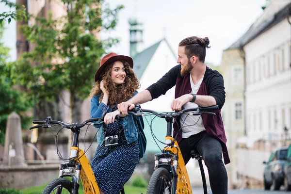 Jovens viajantes casal turístico com scooters elétricos em pequena cidade . — Fotografia de Stock