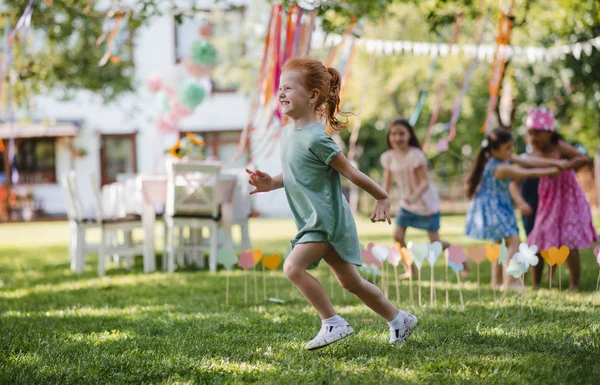 Bambini piccoli che corrono all'aperto in giardino in estate, giocando . — Foto Stock