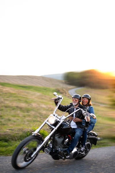 Ένα χαρούμενο ηλικιωμένο ζευγάρι ταξιδιωτών με μοτοσικλέτα στην ύπαιθρο. — Φωτογραφία Αρχείου