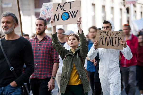Mensen met plakkaten en beschermend pak op wereldwijde staking voor klimaatverandering. — Stockfoto