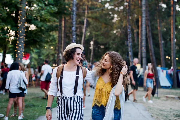 Portrait of two young women friends at summer festival, walking. — Stock Photo, Image