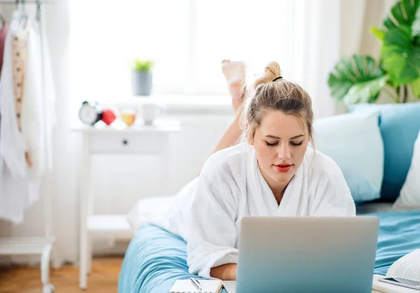 Jovem mulher com laptop na cama em casa de manhã . — Fotografia de Stock